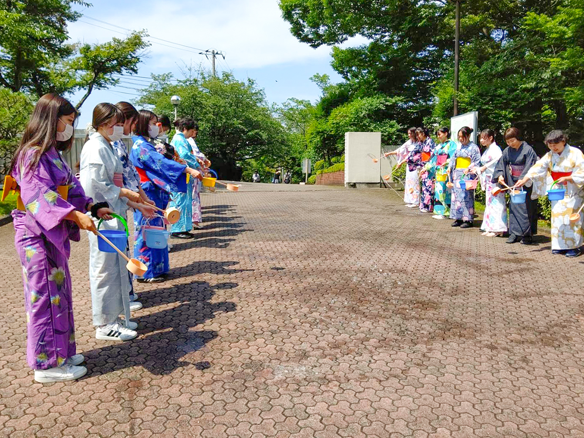 画像：浴衣姿で打ち水をする小田原短期大学の生徒さんたち